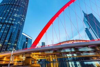 Red bridge with sky scrapers behind 