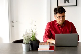 man on laptop in red shirt