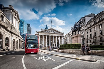 Red bus driving past London landmarks