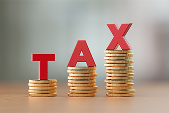 The word tax stacked on coins