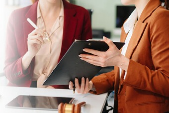 Person signing a document on a clipboard