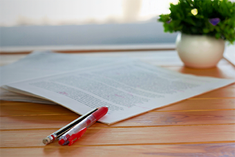 Red pen and paper on a table