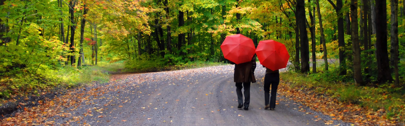 Couple walking under red umbrellas