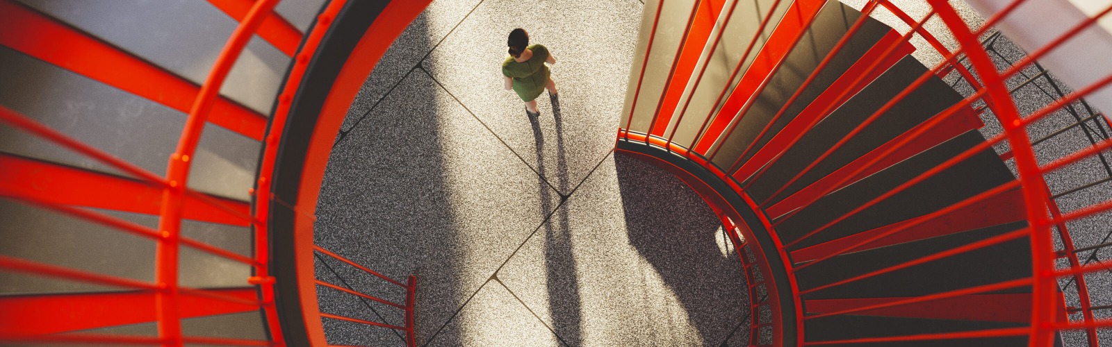 Person at the bottom of a red spiral staircase