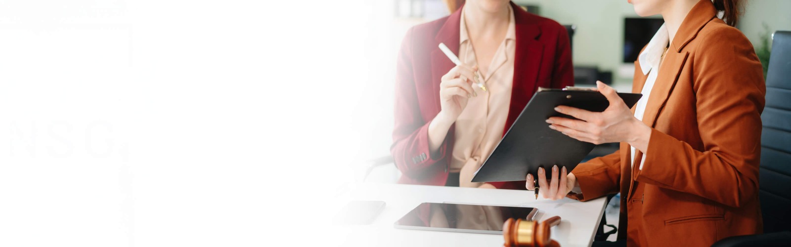 Person signing a document on a clipboard