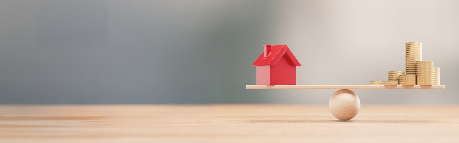 Toy house and coins balancing on a scale 