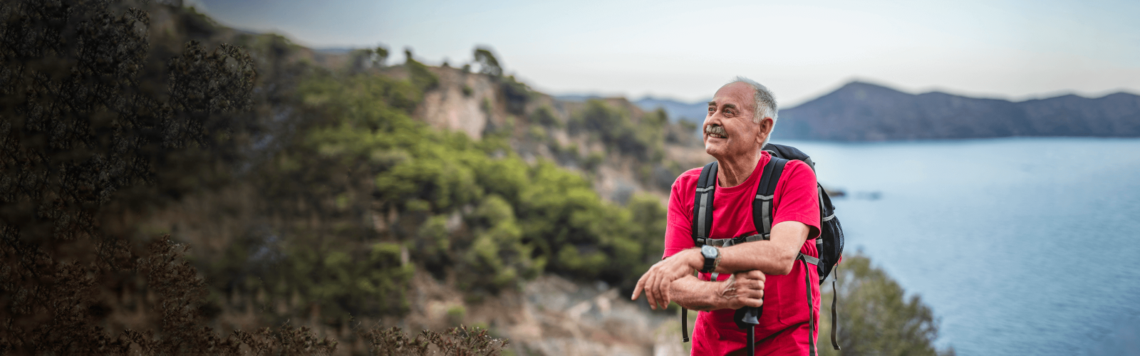 man with red shirt and backpack looking ahead