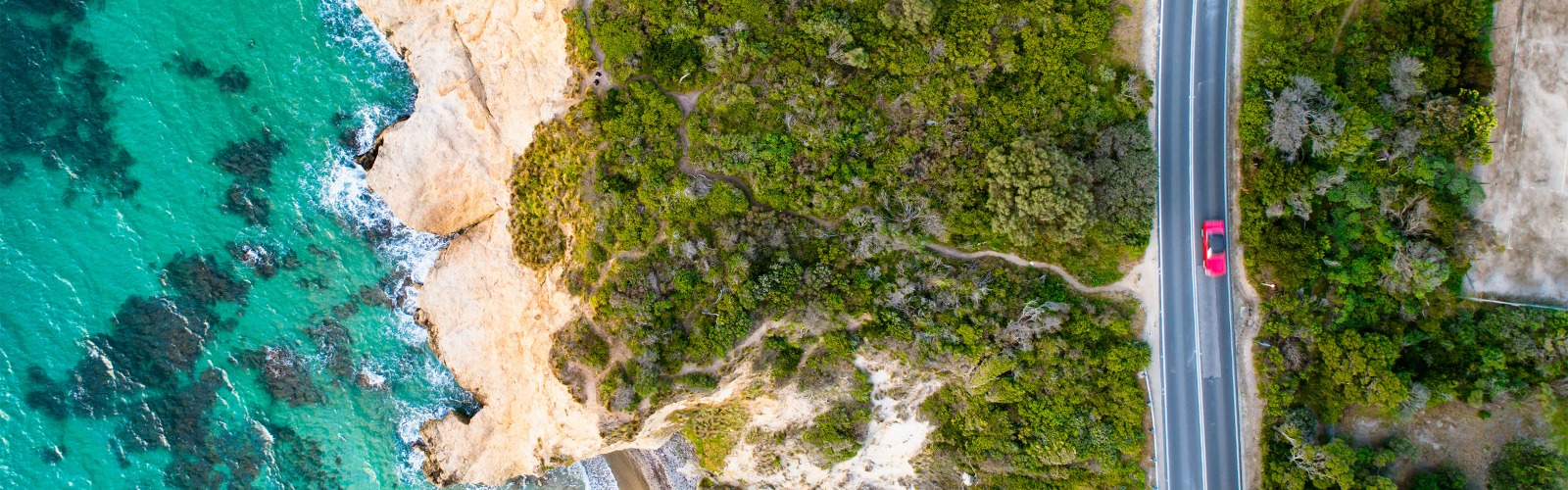 Red Car Driving on Coast