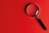 Magnifying glass on red background