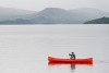 man in a red canoe on a body of water